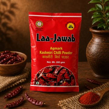 Red bag of Laa-Jawab Kashmiri Chilli Powder on a wooden surface with chili peppers and a plant in the background.
